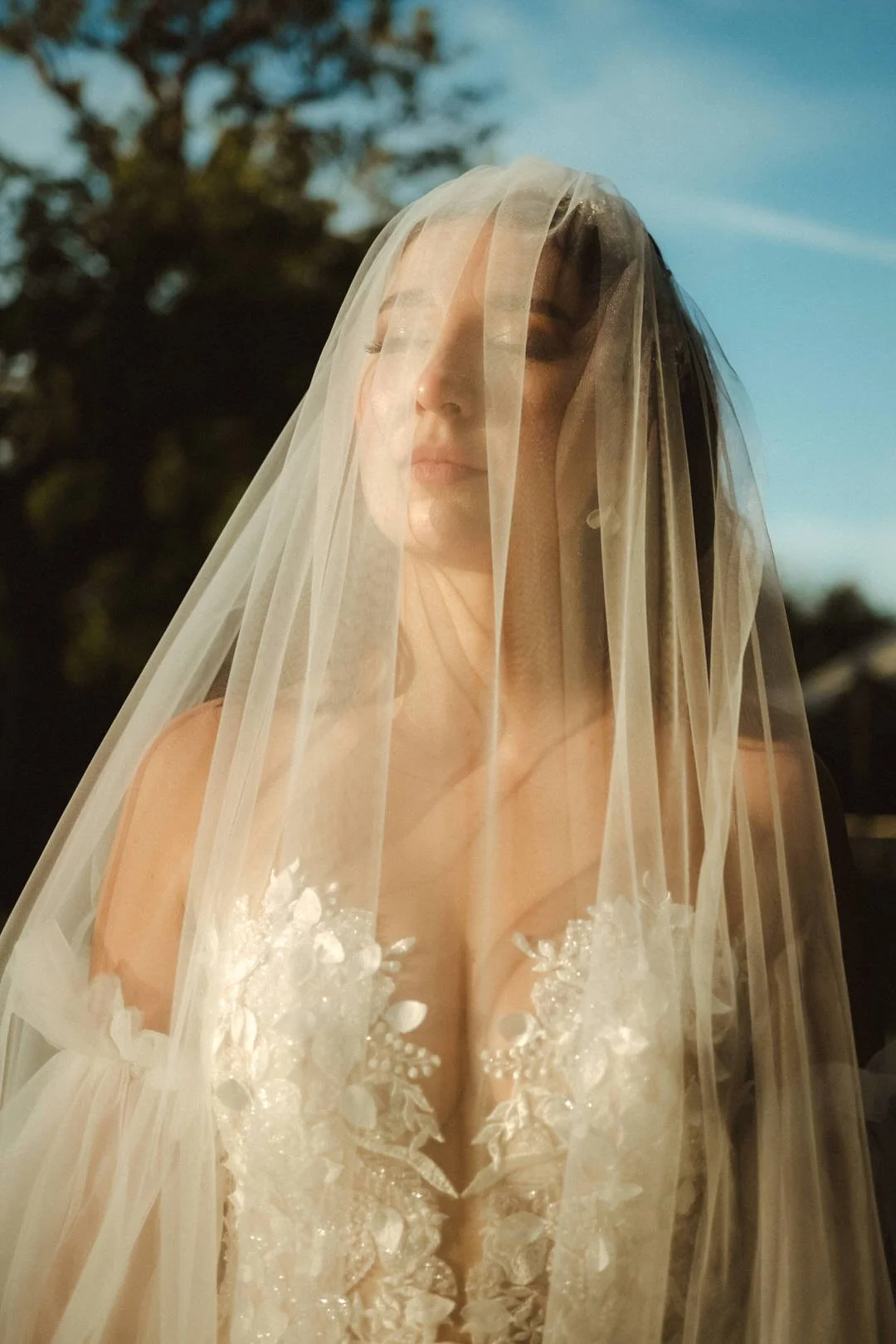 Braut mit Schleier im Sonnenlicht – emotionale Hochzeitsfotografie