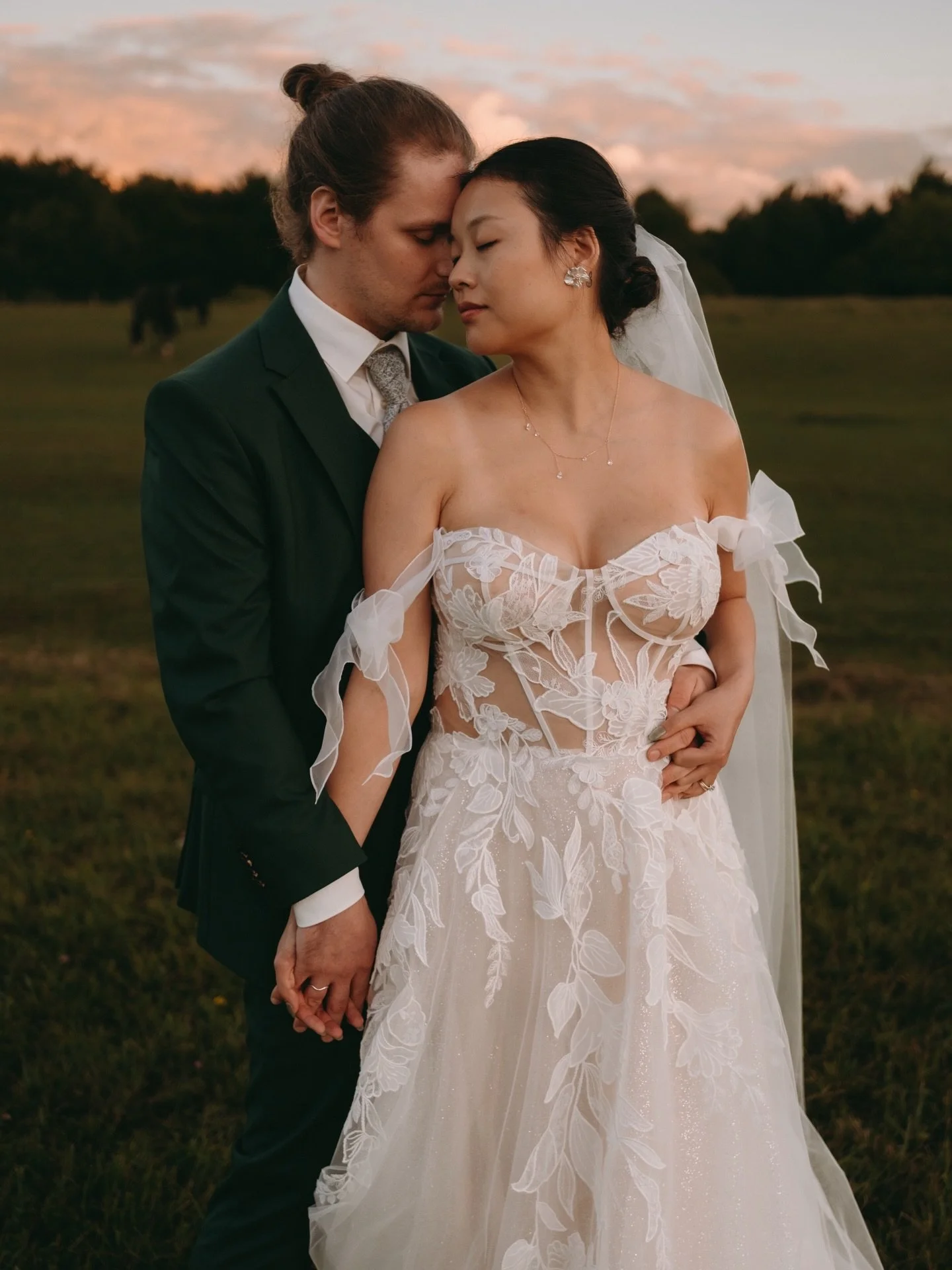 Brautpaar bei Sonnenuntergang auf der Wiese – romantische Hochzeitsbilder